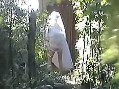 Well-bodied brunette in short skirt decided that she was absolutely alone behind that huge tree, so she took off her pants and began to pee voyeur video #4